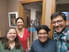 A group of four people in front of an office door that says LISC Duluth