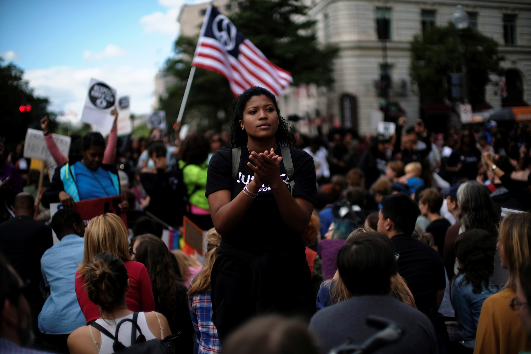A Woman Applauds As Protesters Kneel On One Knee Outside The Trump International Hotel On Pennsylvania Avenue During The March For Racial Justice Calling For Racial Equity And Justice In Washington in September 30, 2017.
